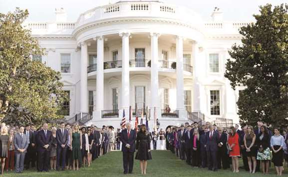 President Donald Trump and first lady Melania Trump observe a moment of silence in remembrance of the 9/11 attacks at the White House in Washington.