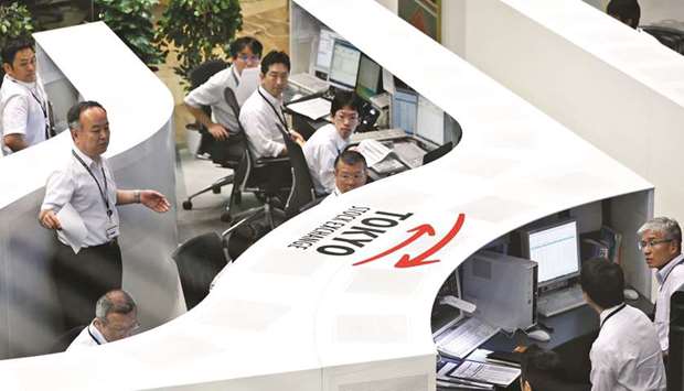 Traders work at the Tokyo Stock Exchange. The Nikkei 225 closed up 1.4% to 19,545.77 points yesterday.