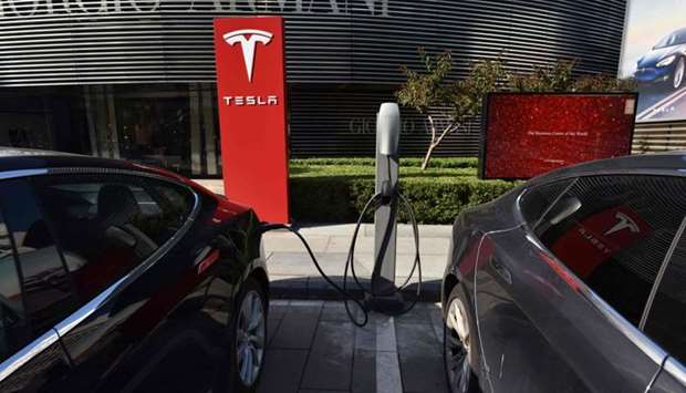 Tesla cars charge at a Tesla charging station outside a shopping mall in Beijing