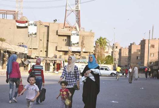 People walk along a street in Deir Ezzor.