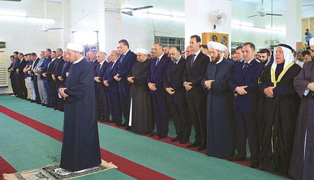 Syriau2019s President Bashar al-Assad attends prayers on the first day of Eid al-Adha, inside a mosque in the town of Qara, north of Damascus.