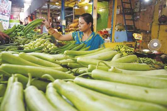 A woman buys vegetables at a market in Ahmedabad yesterday. Inflation rose more than expected to a five-month high in August, fuelled by strong gains in prices of food items.