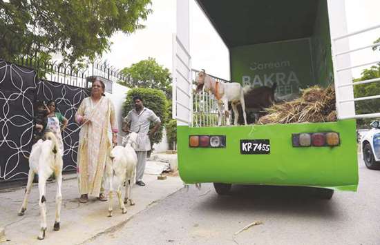 A Careemu2019s car app customer Suryya Baig (L) receives goats from Careemu2019s service ahead of the Muslim festival Eid al-Adha, in Karachi. Pakistanu2019s cattle markets have been crammed for weeks as the country prepares for the sacrificial festival of Eid al-Adha.