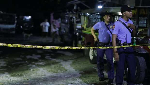 Policemen stand behind a police line in Manila