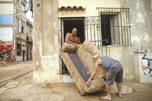 A family carries a sofa out to dry outside their home after Hurricane Irma caused flooding and a blackout, in Havana, Cuba.