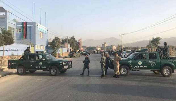 Afghan policemen stand guard at the site of a blast in Kabul, Afghanistan