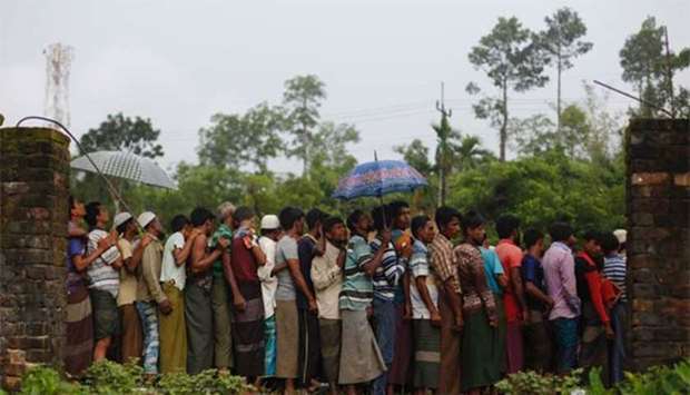 Rohingya refugees wait for food near Balukhali makeshift refugee camp in Cox's Bazar, Bangladesh, on Wednesday.