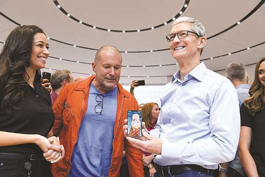 Jony Ive, chief design officer (center) and Tim Cook, CEO, of Apple Inc, view the iPhone X during the launch event at the Steve Jobs Theater in Cupertino, California, on Tuesday. The iPhone X was one of three new iPhone models unveiled at the first event at Appleu2019s new u201cspaceshipu201d campus.