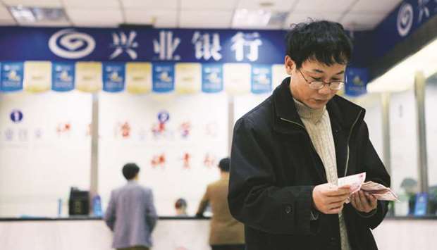 A customer counts his yuan notes at a branch of Industrial Bank Co in Shanghai. The yuan has resumed gains, rising 0.07% to 6.5315 per dollar yesterday in Shanghai, after retreating 0.8% over the previous three days.