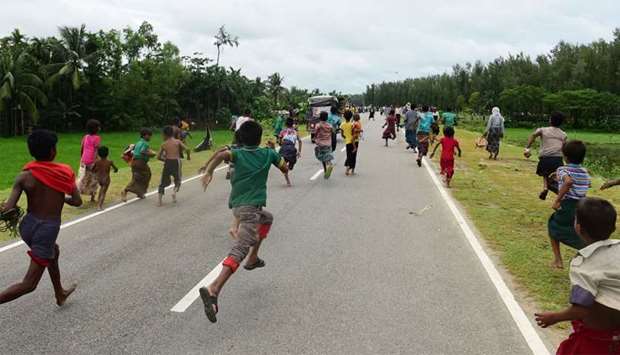 Rohingya Muslim refugees children follow a vehicle with relief supplies