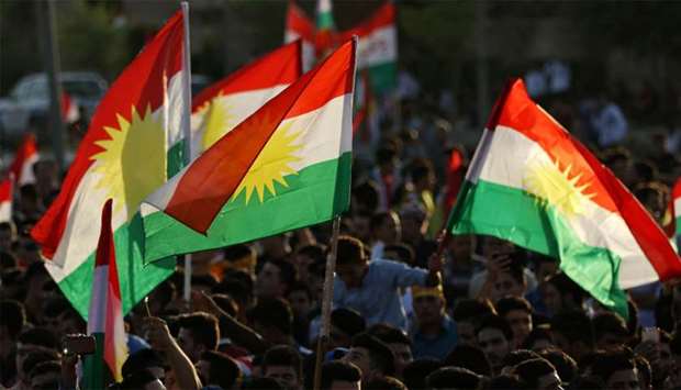 Iraqi Kurds gather in the street flying Kurdish flags as they urge people to vote in the upcoming independence referendum in Arbil