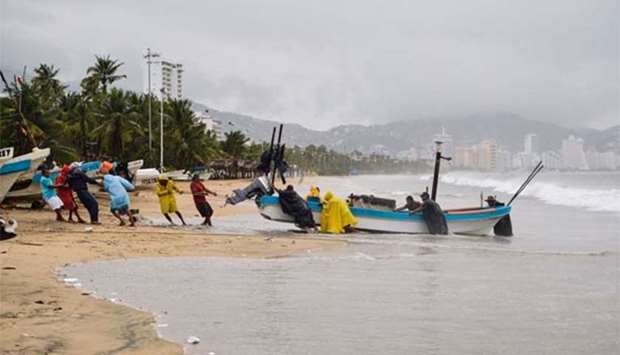 Fishermen take their boats out of the sea in anticipation of the arrival of Hurricane Max in Acapulco, Mexico on Thursday.