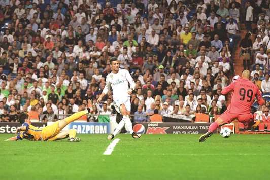 Real Madridu2019s forward from Portugal Cristiano Ronaldo (C) scores past APOEL Nicosiau2019s goalkeeper from the Netherlands Boy Waterman during their UEFA Champions  League match at the Santiago Bernabeu stadium in Madrid on Wednesday.
