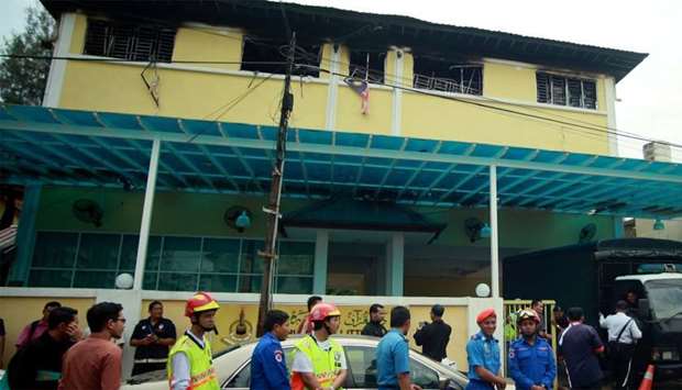 Malaysian Fire and Rescue personnel stand outside the Darul Quran Ittifaqiyah religious school in Kuala Lumpur