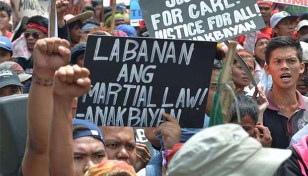 Protesters raise clenched fists next to an anti-martial law placard during a rally near the US embassy in Manila on Friday.