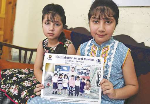 Warisha, right, and Zofisha, sisters of Noeen u2013 who was killed by a stray bullet during celebratory gunfire when Pakistan won the ICC Champions trophy against its arch rival India u2013 hold a photograph featuring him at his residence in the northwestern town of Nowshera, in Khyber Pakhtunkhwa province.