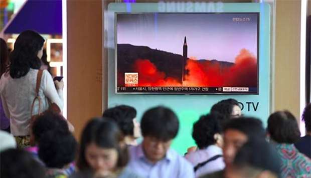 People watch a screen showing file footage of a North Korean missile launch, at a railway station in Seoul on Friday.