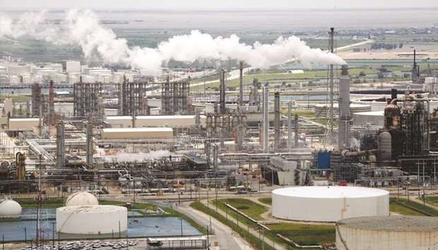 Emissions rise from a Marathon Petroleum Corp oil refinery in Texas. Oil investors eye further impact from increasing crude demand from US oil refineries restarting after hurricane outages.