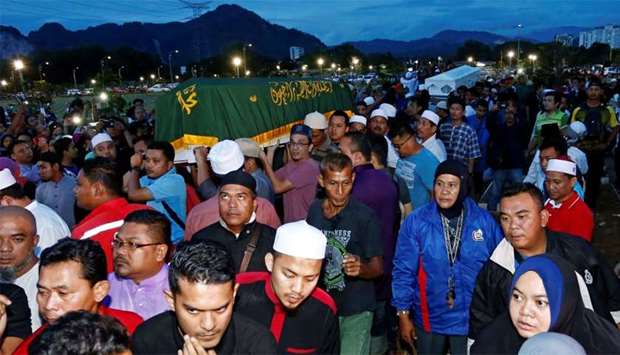 People carry caskets containing Darul Quran Ittifaqiyah religious school fire victims in Kuala Lumpur