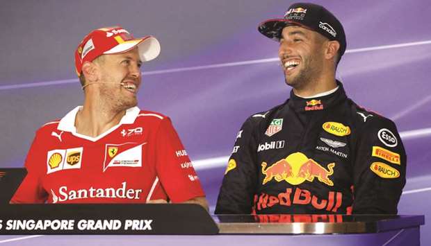 Ferrariu2019s Sebastian Vettel (left) and Red Bullu2019s Daniel Ricciardo share a laugh after the qualifying session during the Singapore Grand Prix. (Reuters)