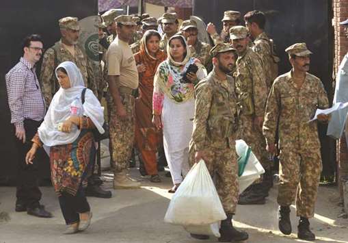 Army soldiers help polling officers carry election materials received from the election commission office in Lahore yesterday, for the by-election of the parliamentary seat held by Pakistanu2019s ousted former prime minister.