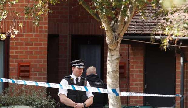 A police officer stands outside a property being searched after a man was arrested in connection with an explosion on a London Underground train, in Stanwell, near Heathrow airport, Britain