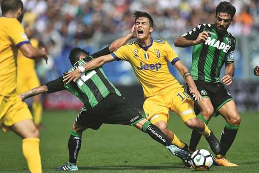 Juventusu2019 Paulo Dybala (centre) vies for the ball with Sassuolou2019s Stefano Sensi (left) and Francesco Magnanelli during the Italian Serie A match yesterday. (AFP)