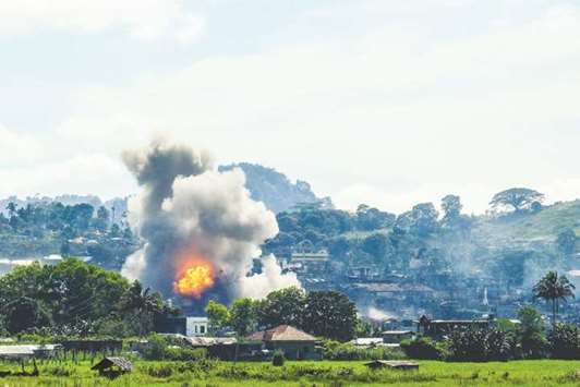 Smoke billows from houses after aerial bombings by Philippine Air Force planes on militant positions in Marawi on the southern island of Mindanao yesterday.