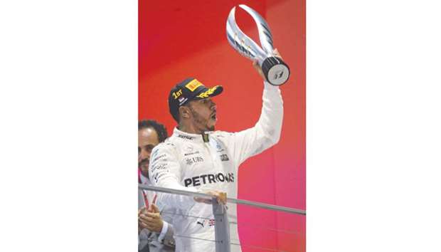 Mercedesu2019 British driver Lewis Hamilton with the  Singapore Grand Prix trophy.
