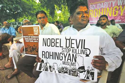 People hold placards during a protest against Myanmaru2019s persecution of Rohingya Muslims, in Ahmedabad yesterday.