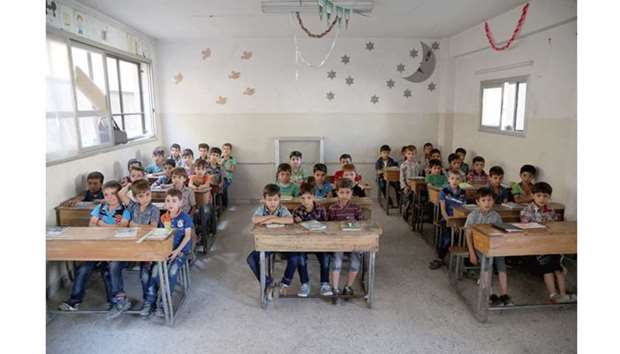 Syrian pupils sit at their desks during class in a school in the rebel-held Eastern Ghouta town of Douma yesterday.