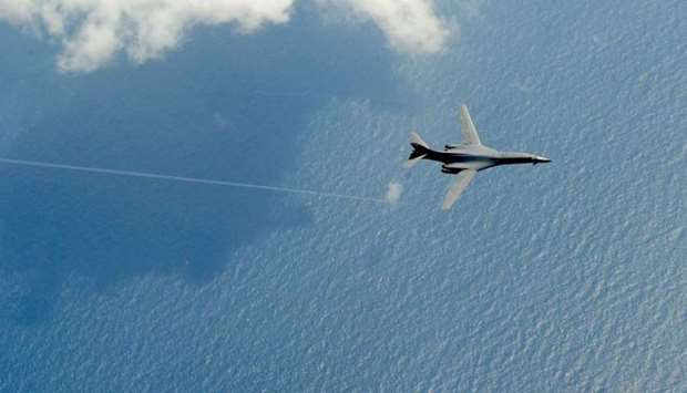 A B-1B bomber flies over the sea.