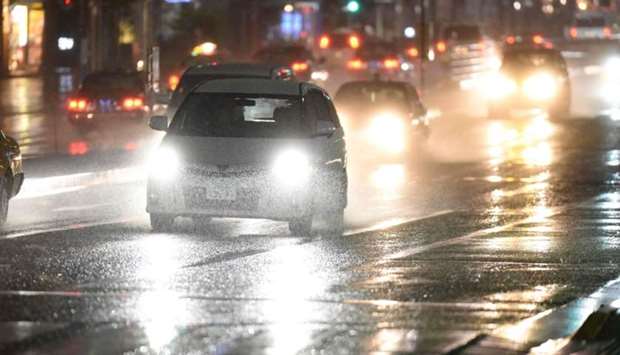 Vehicles drive through rain caused by weather patterns from Typhoon Talim in Tokyo