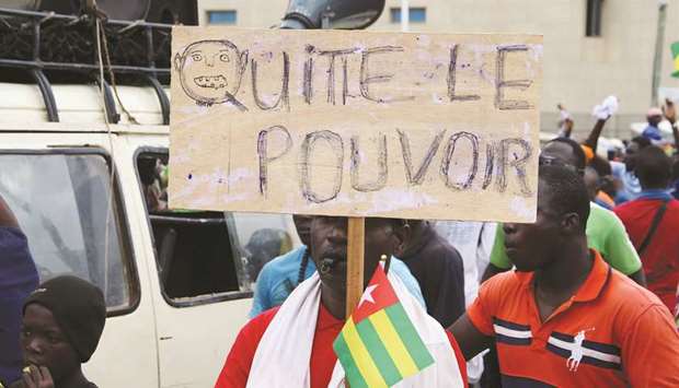 A man holds up a sign which reads u2018leave poweru2019 during opposition protest in Lome earlier this month.