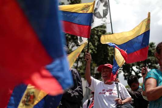 A supporter of President Nicolas Maduro waves a national flag during a rally against imperialism in Caracas, Venezuela, yesterday.