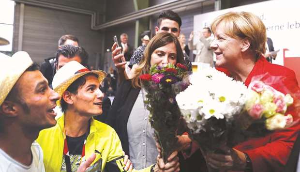 Merkel receives flowers from a refugee after she gave a speech at an election rally in Schwerin, northern Germany.