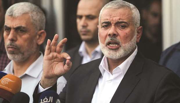Hamas chief Ismail Haniya (right) speaks to the press upon his arrival on the Palestinian side of the Rafah border crossing, in the southern Gaza Strip, yesterday.