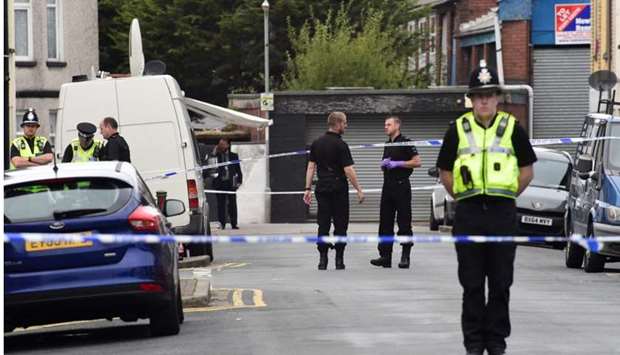 Officers stand behind police cordon after three men were arrested in connection with an explosion on the London Underground, in Newport, Wales, Britain.