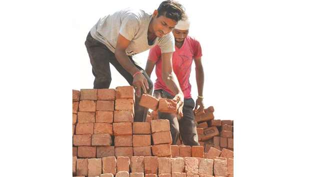 Labourers load bricks onto a tractor trolley at a brick kiln on the outskirts of Amritsar. Brick kiln workers in India are trapped in a cycle of bonded labour and regularly cheated out of promised wages, says a report.