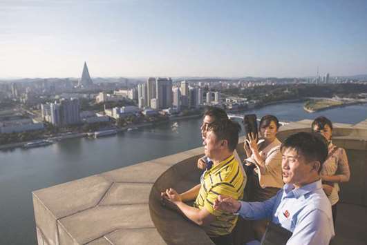 A group of North Korean tourists stand before the city skyline atop the Juche tower in Pyongyang yesterday.