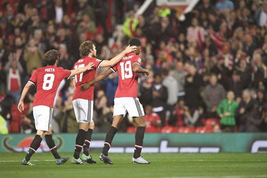 Manchester Unitedu2019s English striker Marcus Rashford (right) celebrates scoring his teamu2019s second goal during the English League Cup third round match against Burton Albion at Old Trafford in Manchester. (AFP)