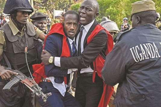 Students of Makerere University are detained by police officers during a protest in Kampala against the move to scrap the presidential age limit.