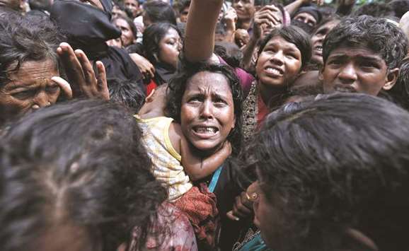 A woman reacts as Rohingya refugees wait to receive aid in Coxu2019s Bazar.