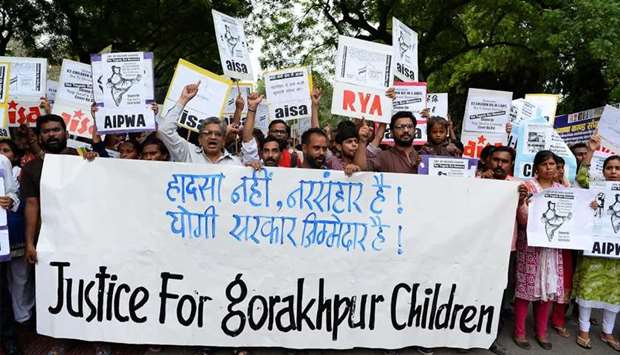 Activists and Indian students hold placards as they shout slogans during a protest