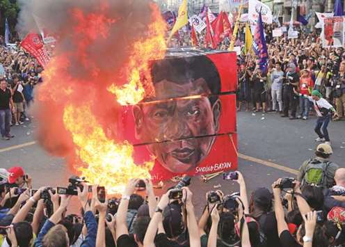 Protesters burn a cube effigy with a face of President Duterte during a National Day of Protest outside the presidential palace in metro Manila, Philippines.