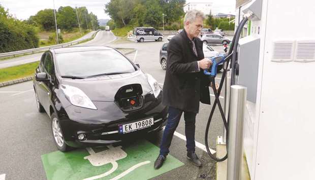 Arne Nordboe recharges his Nissan Leaf electric car in Finnoey, Norway.