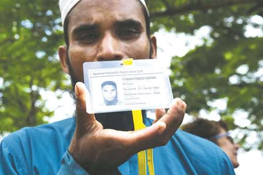 Rohingya refugee Mohamed Sayedb shows his Myanmaru2019s national registration card at the entrance of a Bangladeshi government registration office in the refugee camp of  Kutupalong near Ukhia.