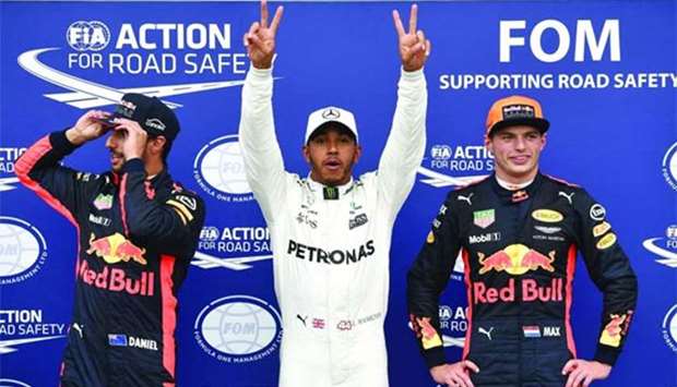 Mercedes' British driver Lewis Hamilton (centre) celebrates winning the pole position next to second placed Red Bull's Dutch driver Max Verstappen (right) and third placed Red Bull's Australian driver Daniel Ricciardo after the qualifying session at the Autodromo Nazionale circuit in Monza on Saturday.