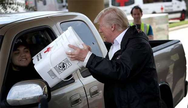 President Donald Trump hands out emergency supplies to residents impacted by Hurricane Harvey while visiting the First Church of Pearland in Pearland, Texas on Saturday.
