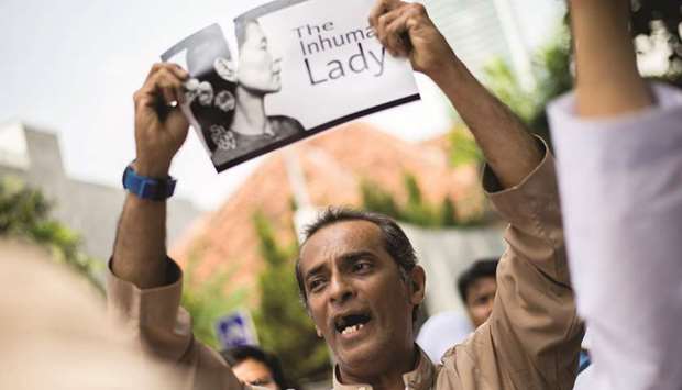 An Indonesian protester tears a picture of Myanmaru2019s Aung San Suu Kyi during a rally in front of Myanmar embassy in Jakarta yesterday to condemn Myanmaru2019s army and the government of Aung San Suu Kyi.